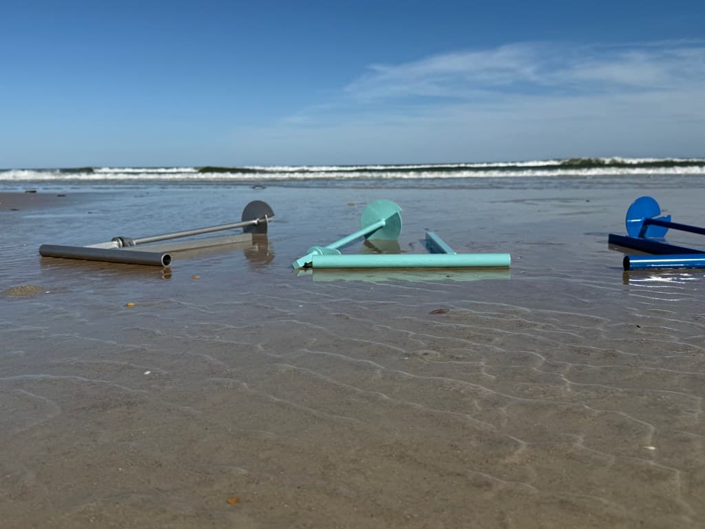 Iron Marine anchors in the surf at the water's edge